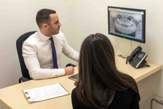 Dr. Arian Noveir going over x-rays with a patient.