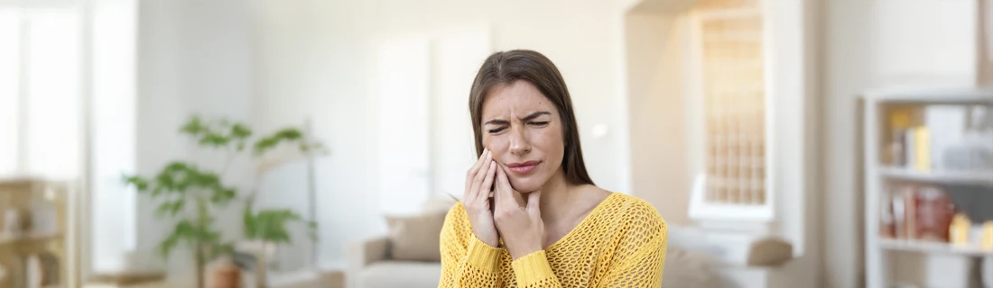 Dentist Northridge CA Dental Emergancy A woman holding her mouth in pain.
