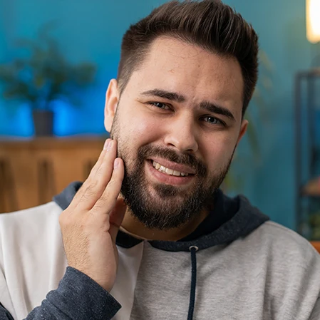 A man holding his jaw in pain.